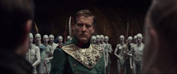 Movie still from “Valerian and the City of a Thousand Planets” (2017), directed by Luc Besson – A man in a military uniform standing in front of a group of people; Medium shot, Over the shoulder angle