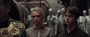 Movie still from “Valerian and the City of a Thousand Planets” (2017), directed by Luc Besson – A woman standing in front of a group of people; Medium shot, Over the shoulder angle