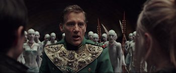 Movie still from “Valerian and the City of a Thousand Planets” (2017), directed by Luc Besson – A man in a green military uniform with a bunch of people in the background; Close Up shot, Over the shoulder angle