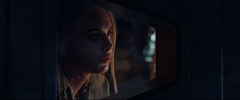 Movie still from “Valerian and the City of a Thousand Planets” (2017), directed by Luc Besson – A woman looking out of a train window at night; Close Up shot, Over the shoulder angle