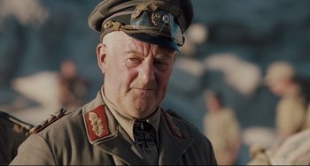 Movie still from “Valkyrie” (2008), directed by Bryan Singer – An older man in a military uniform with a cross on his neck; Close Up shot, Low angle