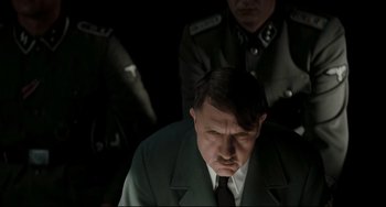 Movie still from “Valkyrie” (2008), directed by Bryan Singer – A man in a suit and tie next to another man in a uniform; Medium shot, High angle