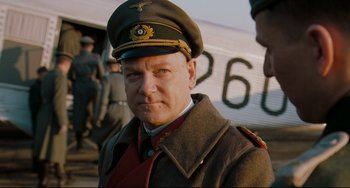 Movie still from “Valkyrie” (2008), directed by Bryan Singer – A man in a military uniform standing in front of an airplane; Close Up shot, Over the shoulder angle