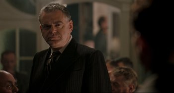 Movie still from “Valkyrie” (2008), directed by Bryan Singer – An older man wearing a suit and tie; Close Up shot, Over the shoulder angle