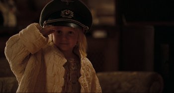 Movie still from “Valkyrie” (2008), directed by Bryan Singer – A little girl wearing a hat saluting with her hand on her head; Close Up shot, Over the shoulder angle
