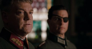 Movie still from “Valkyrie” (2008), directed by Bryan Singer – Two men in military uniforms are standing next to each other; Close Up shot, Over the shoulder angle