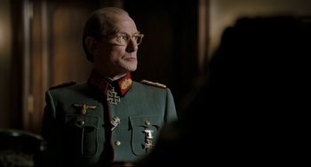Movie still from “Valkyrie” (2008), directed by Bryan Singer – An older man in a military uniform wearing glasses; Close Up shot, Over the shoulder angle