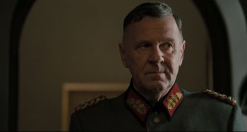 Movie still from “Valkyrie” (2008), directed by Bryan Singer – An older man in a military uniform looking at the camera; Close Up shot, Over the shoulder angle