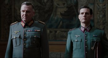 Movie still from “Valkyrie” (2008), directed by Bryan Singer – A man and a man in military uniforms; Medium shot, Low angle