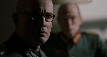 Movie still from “Valkyrie” (2008), directed by Bryan Singer – A man in glasses and a man in a military uniform; Close Up shot, Low angle