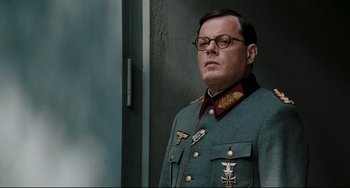 Movie still from “Valkyrie” (2008), directed by Bryan Singer – A man in a military uniform standing in front of a wall; Close Up shot, Low angle