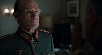 Movie still from “Valkyrie” (2008), directed by Bryan Singer – An older man in a military uniform with glasses; Close Up shot, Over the shoulder angle