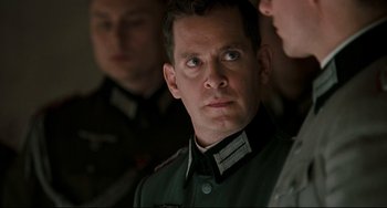 Movie still from “Valkyrie” (2008), directed by Bryan Singer – A person wearing a military uniform; Close Up shot, Over the shoulder angle