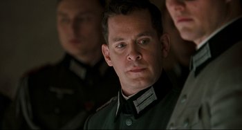 Movie still from “Valkyrie” (2008), directed by Bryan Singer – A person wearing a military uniform; Close Up shot, Over the shoulder angle