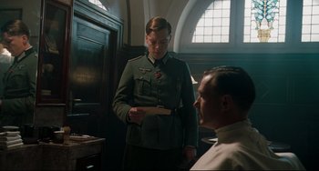 Movie still from “Valkyrie” (2008), directed by Bryan Singer – A man in a military uniform standing next to another man; Medium shot, Low angle