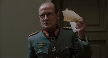 Movie still from “Valkyrie” (2008), directed by Bryan Singer – An older man in a military uniform holding a piece of paper in his hand; Close Up shot, Low angle