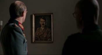 Movie still from “Valkyrie” (2008), directed by Bryan Singer – A painting of adolf hitler hanging on the wall; Close Up shot, Over the shoulder angle