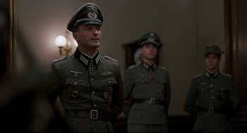 Movie still from “Valkyrie” (2008), directed by Bryan Singer – Two men in military uniforms are standing in a room; Medium shot, Low angle