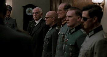 Movie still from “Valkyrie” (2008), directed by Bryan Singer – A group of men standing next to each other in uniforms; Medium shot, Over the shoulder angle