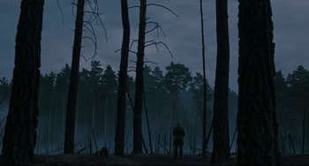 Movie still from “Valkyrie” (2008), directed by Bryan Singer – A man standing in the middle of a forest at night; Extreme Wide shot, High angle