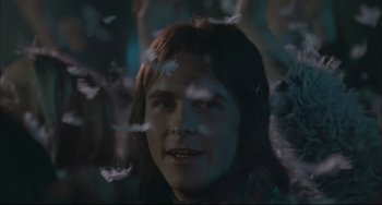 Movie still from “Velvet Goldmine” (1998), directed by Todd Haynes – A man with long brown hair is surrounded by butterflies; Close Up shot, Low angle