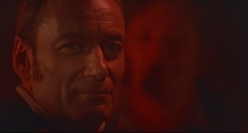 Movie still from “Velvet Goldmine” (1998), directed by Todd Haynes – A man's face in red light; Close Up shot, Low angle