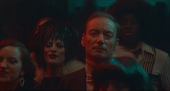 Movie still from “Velvet Goldmine” (1998), directed by Todd Haynes – A man and a woman are standing in a room; Close Up shot, Over the shoulder angle