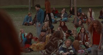 Movie still from “Velvet Goldmine” (1998), directed by Todd Haynes – A group of people sitting on the grass; Wide shot, High angle