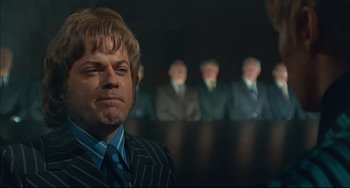 Movie still from “Velvet Goldmine” (1998), directed by Todd Haynes – A person wearing a suit and tie; Close Up shot, Low angle