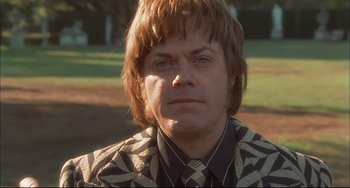 Movie still from “Velvet Goldmine” (1998), directed by Todd Haynes – A person wearing a suit and tie; Close Up shot, Low angle