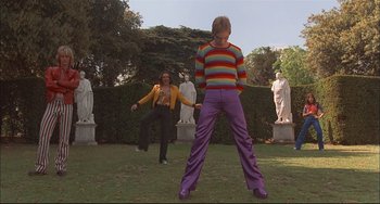 Movie still from “Velvet Goldmine” (1998), directed by Todd Haynes – A man and a woman are standing in the grass; Wide shot, Low angle
