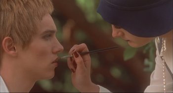 Movie still from “Velvet Goldmine” (1998), directed by Todd Haynes – A man is holding a pair of scissors up to his face; Close Up shot, Low angle