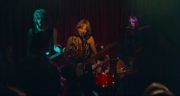 Movie still from “Velvet Goldmine” (1998), directed by Todd Haynes – A group of people that are playing a song; Wide shot, Low angle