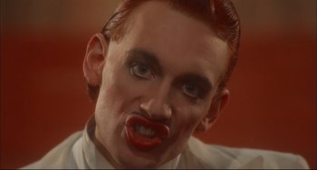 Movie still from “Velvet Goldmine” (1998), directed by Todd Haynes – A person with red lipstick on their lips; Close Up shot, Low angle