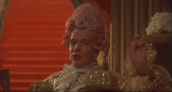 Movie still from “Velvet Goldmine” (1998), directed by Todd Haynes – A man in a pink wig and a white bow tie; Close Up shot, Low angle