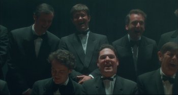 Movie still from “Velvet Goldmine” (1998), directed by Todd Haynes – A group of men standing next to each other in tuxedos; Medium shot, Low angle