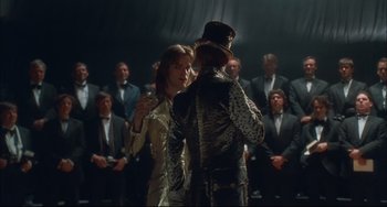 Movie still from “Velvet Goldmine” (1998), directed by Todd Haynes – A man and a woman dancing in front of an audience; Medium shot, Over the shoulder angle