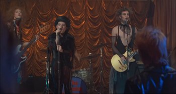 Movie still from “Velvet Goldmine” (1998), directed by Todd Haynes – A couple of people that are on a stage; Medium shot, Low angle