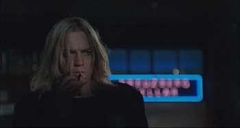 Movie still from “Velvet Goldmine” (1998), directed by Todd Haynes – A man smoking a cigarette in front of a row of pink balls; Close Up shot, Low angle