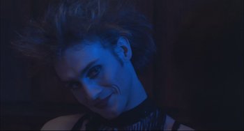 Movie still from “Velvet Goldmine” (1998), directed by Todd Haynes – A man with blue light shining on his face; Close Up shot, Low angle