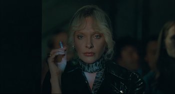 Movie still from “Velvet Goldmine” (1998), directed by Todd Haynes – A woman holding a cigarette in her hand; Close Up shot, Low angle