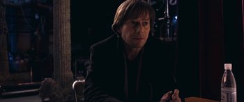 Movie still from “Venus in Fur” (2013), directed by Roman Polanski – A man sitting in a chair in a dark room; Close Up shot, Over the shoulder angle