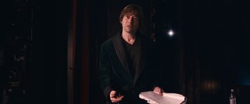 Movie still from “Venus in Fur” (2013), directed by Roman Polanski – A man in a black jacket holding papers; Medium shot, Over the shoulder angle