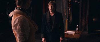 Movie still from “Venus in Fur” (2013), directed by Roman Polanski – A man in a black robe standing in a dark room; Medium shot, Over the shoulder angle