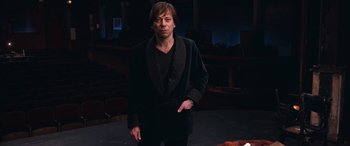Movie still from “Venus in Fur” (2013), directed by Roman Polanski – A man in a black jacket standing on a stage; Medium shot, Low angle