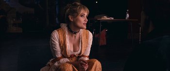 Movie still from “Venus in Fur” (2013), directed by Roman Polanski – A woman sitting on the ground wearing a yellow dress; Medium shot, High angle