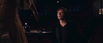 Movie still from “Venus in Fur” (2013), directed by Roman Polanski – A man sitting in front of an audience in a theater; Medium shot, Over the shoulder angle