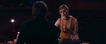 Movie still from “Venus in Fur” (2013), directed by Roman Polanski – A woman talking to a man at a table; Medium shot, Over the shoulder angle