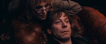 Movie still from “Venus in Fur” (2013), directed by Roman Polanski – A man and a woman laying on a leather couch; Close Up shot, Overhead angle