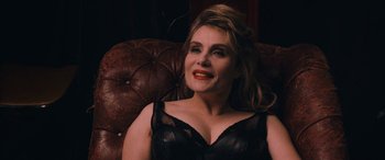Movie still from “Venus in Fur” (2013), directed by Roman Polanski – A woman sitting on top of a brown leather couch; Close Up shot, Over the shoulder angle